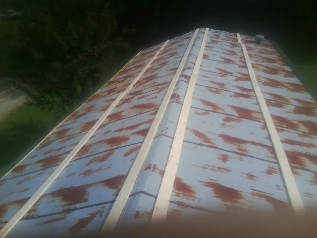 Rusted metal roof panels with new wood purlins before replacement — Storm Damage Roof Repair in Glade Spring by Roofing Brothers