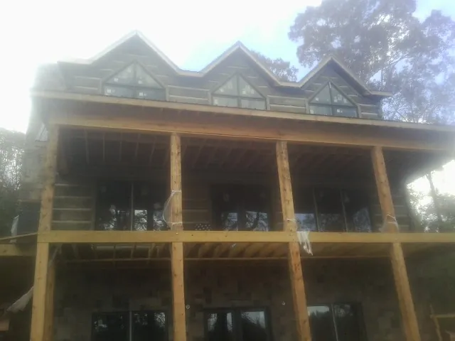 Dormers and porch framing on a large log home under construction — Roof Coating work by our crew in Glade Spring