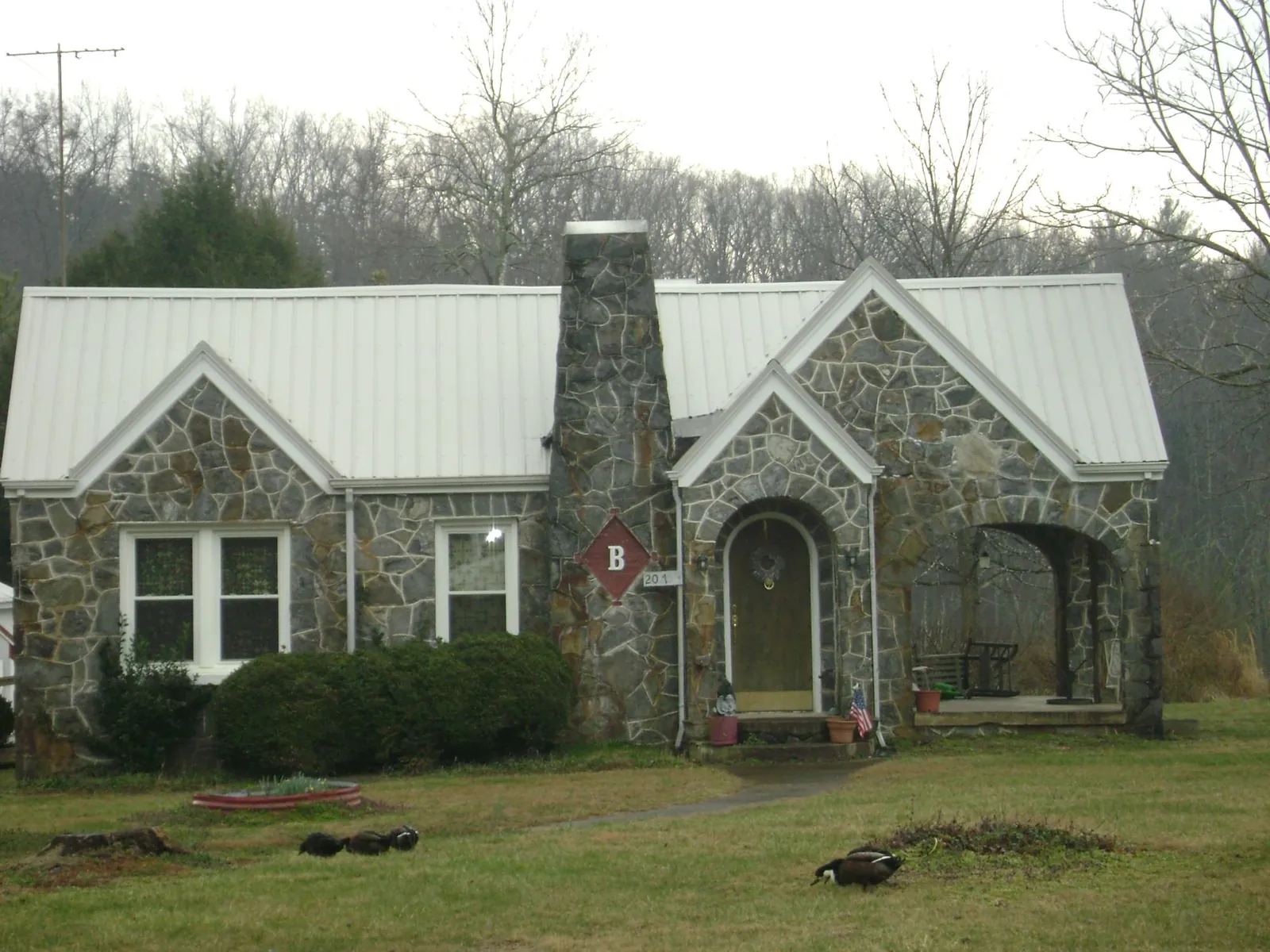 White metal roof on a stone cottage with steep gables in Glade Spring