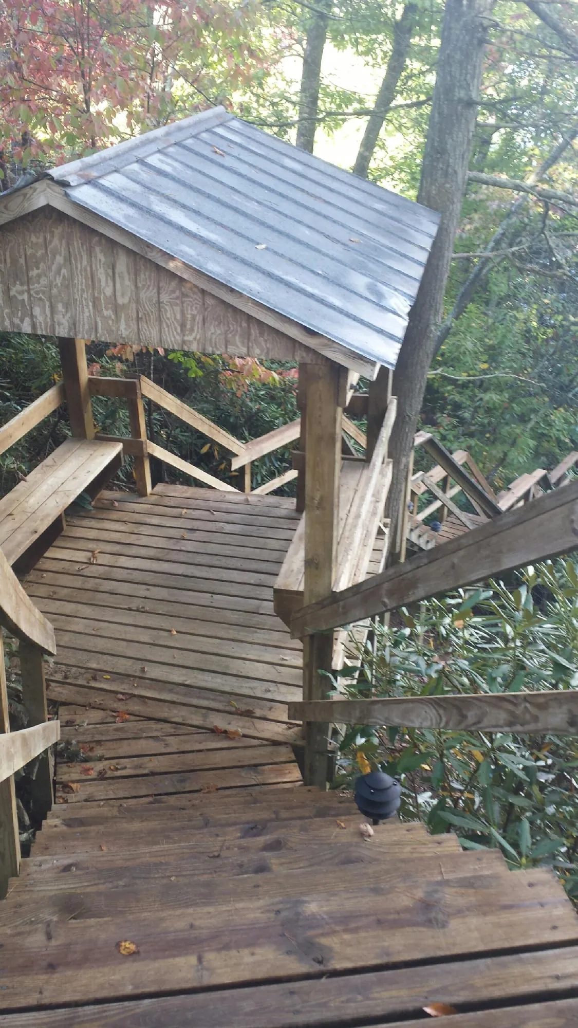 Metal roofed shelter over wooden steps on a wooded walkway — Skylight Repair & Installation work by our crew in Glade Spring