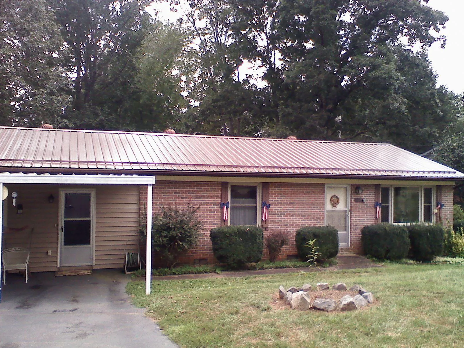 Bronze metal roof and carport on a brick ranch home — Roof Repair work by our crew in Glade Spring